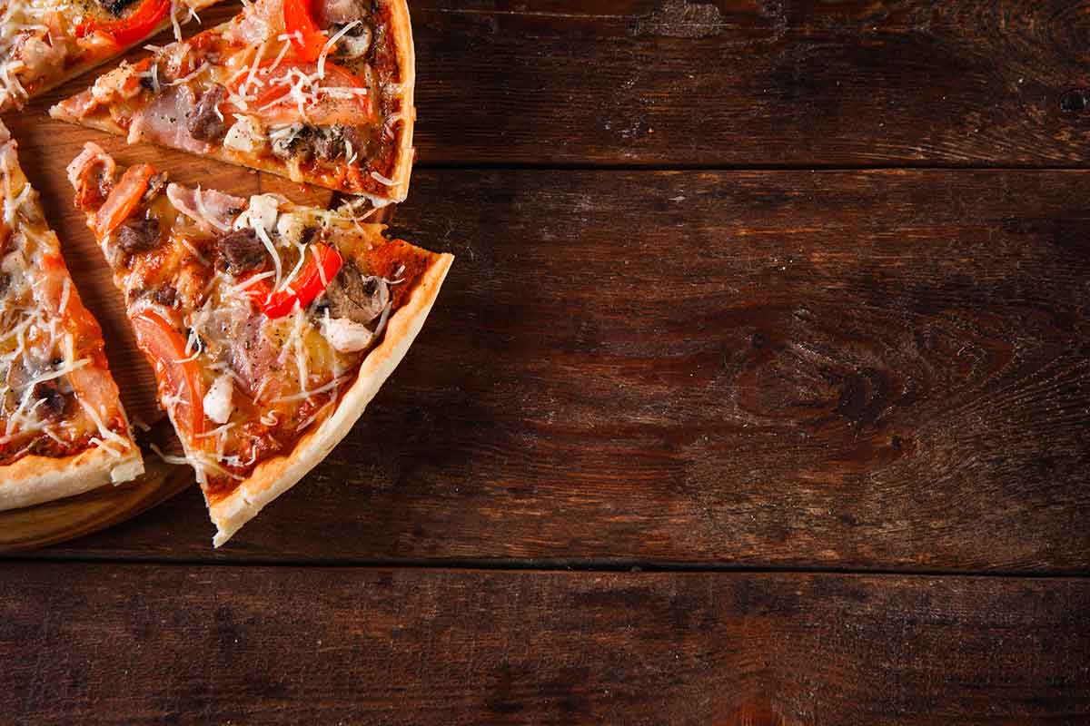 Пицца на темном деревянном фоне