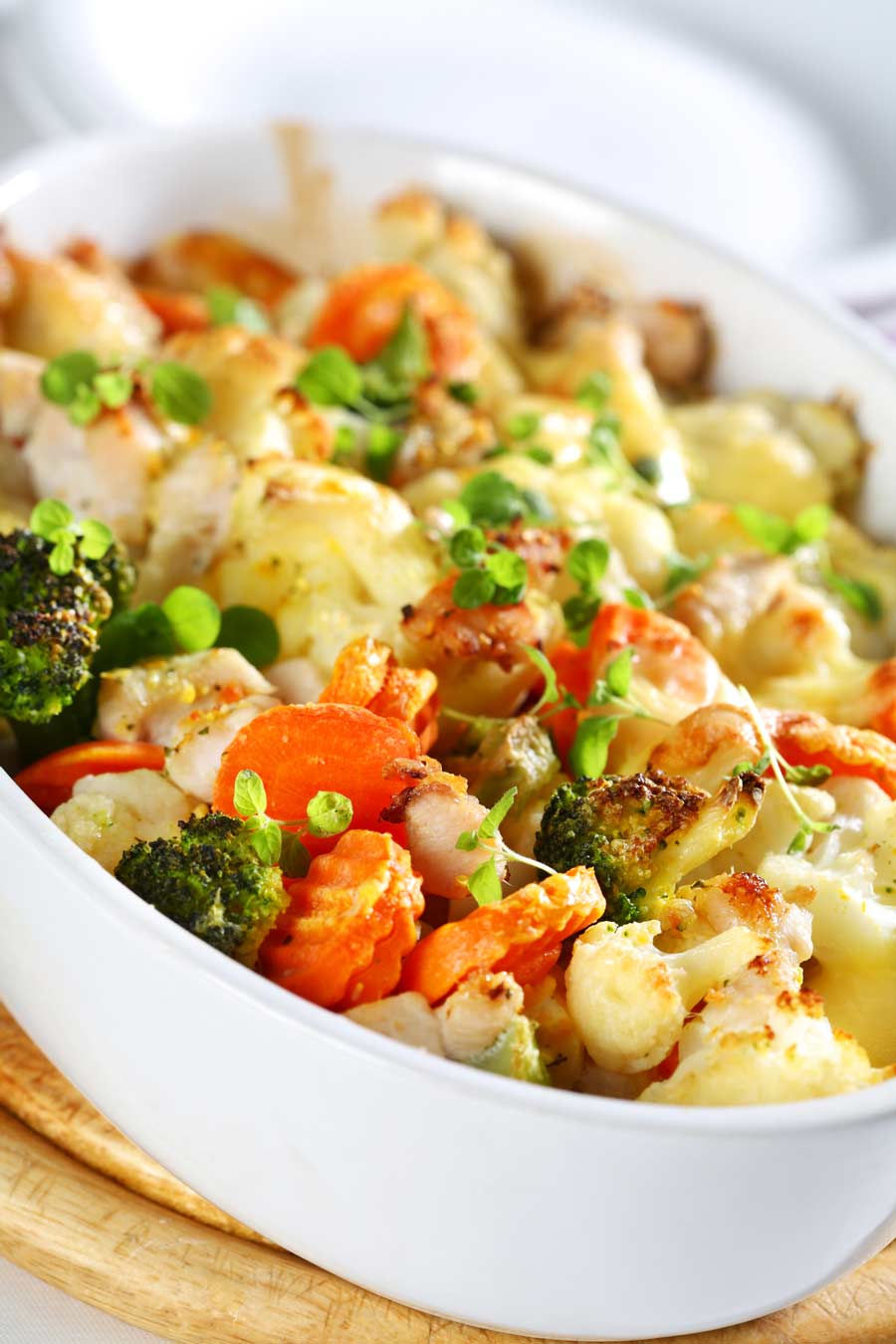 A medley of baked mixed vegetables such as carrots, broccoli and cauliflower with cheese