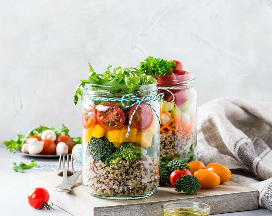 A mason jar filled with healthy salad ingredients.
