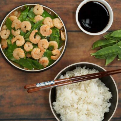 Shrimp stir fry with a side of rice and chopsticks