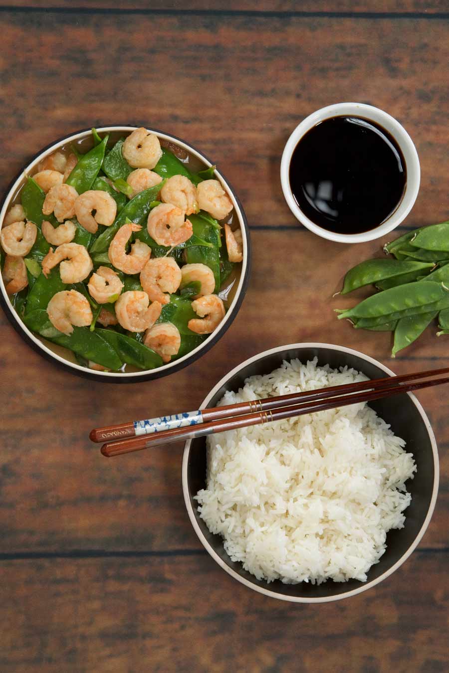 Shrimp stir fry with a side of rice and chopsticks