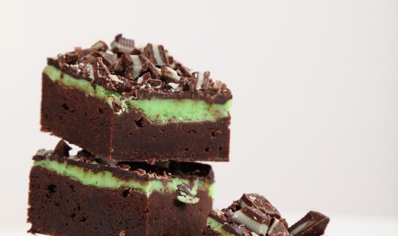 Chocolate mint brownies stacked on a white background.