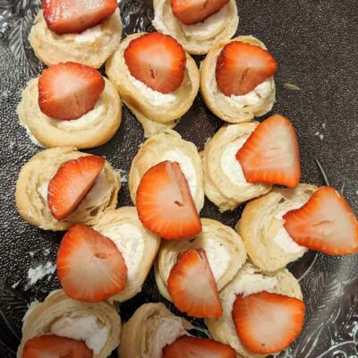 French twirls covered with whipped cream and strawberries