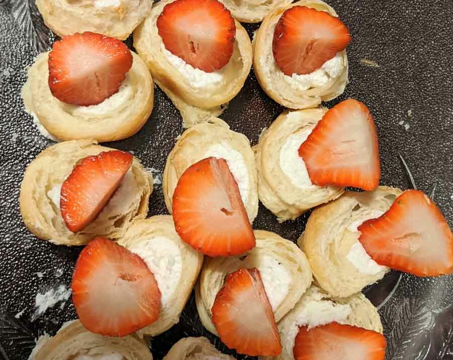 French twirls covered with whipped cream and strawberries