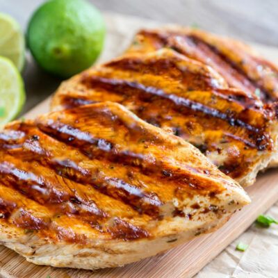 Tequila Lime grilled chicken on a plate, with lime wedges on the side