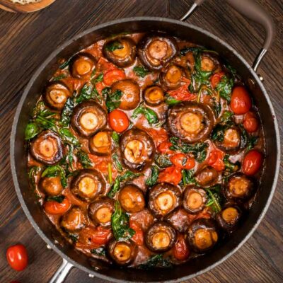 Mushrooms with tomatoes and spinach in a skillet