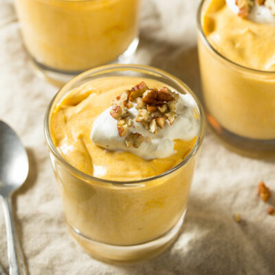 A glass jar of pumpkin whip pudding with whipped cream