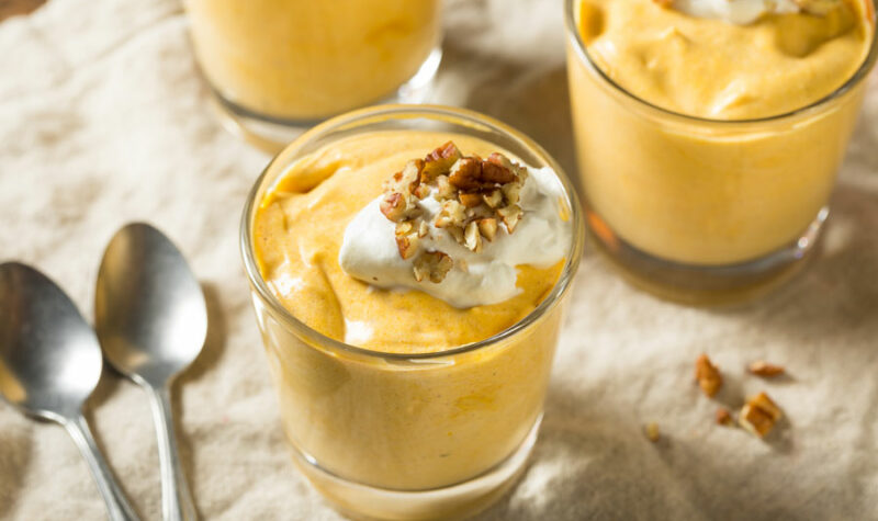 A glass jar of pumpkin whip pudding with whipped cream