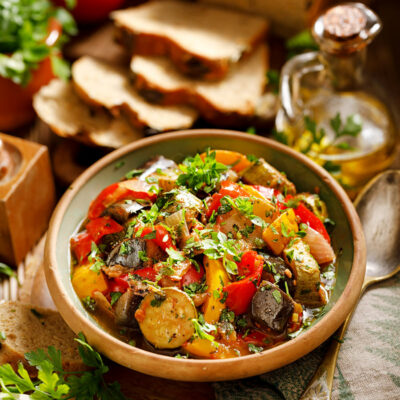 Easy Veg Ratatouille in a brown bowl with bread.