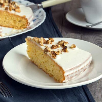 A white cake with nuts on top.