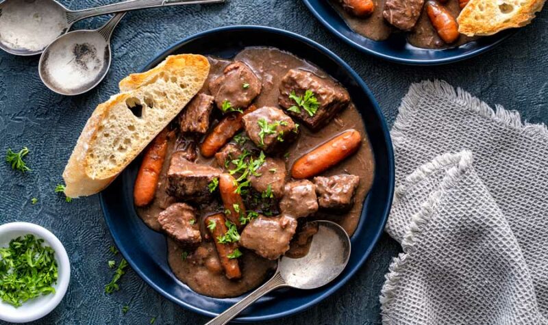 Beef stew with a slice of french bread next to it