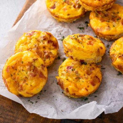 Bacon and cheddar cheese egg bites on parchment paper