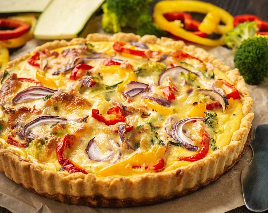 A quiche with bell peppers, mushrooms.