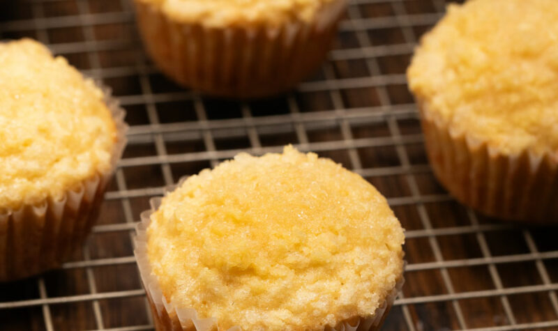 Lemon Crumb Muffins on a gold baking sheet