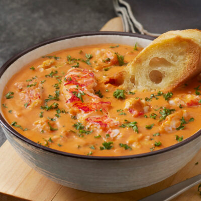 Lobster Bisque soup in a white bowl with bread