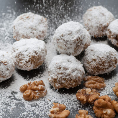 Homemade walnut snowball cookies with confectioners sugar.