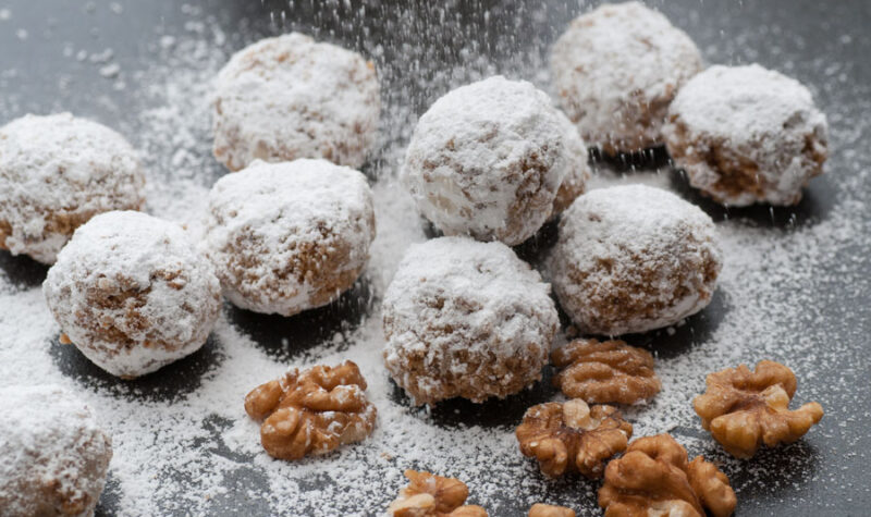 Homemade walnut snowball cookies with confectioners sugar.