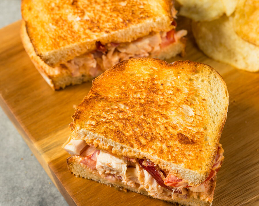 Southwest Panini sandwich on a cutting board with chips