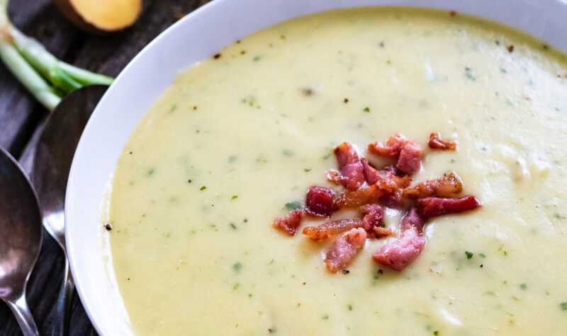 Potato soup in a white bowl with bacon pieces