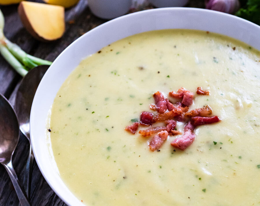 Potato soup in a white bowl with bacon pieces
