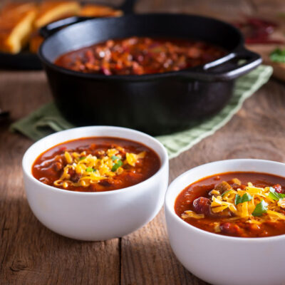 Bean chili in white bowls topped with cheese