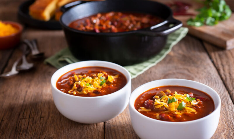Bean chili in white bowls topped with cheese