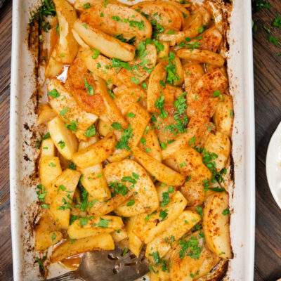 Greek Roasted Potatoes in a casserole dish sprinkled with paprika