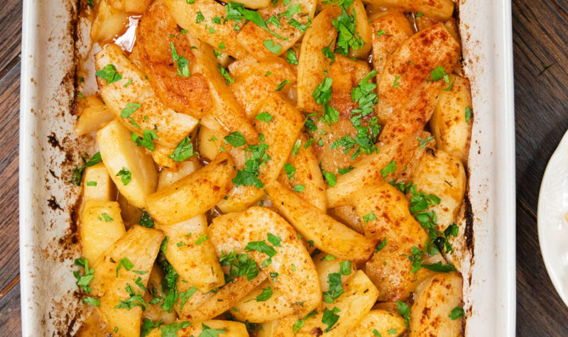 Greek Roasted Potatoes in a casserole dish sprinkled with paprika