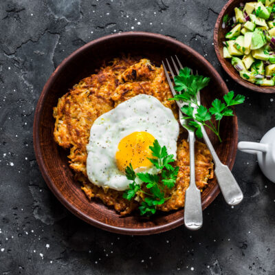 A potato pancake on a plate with an egg on top