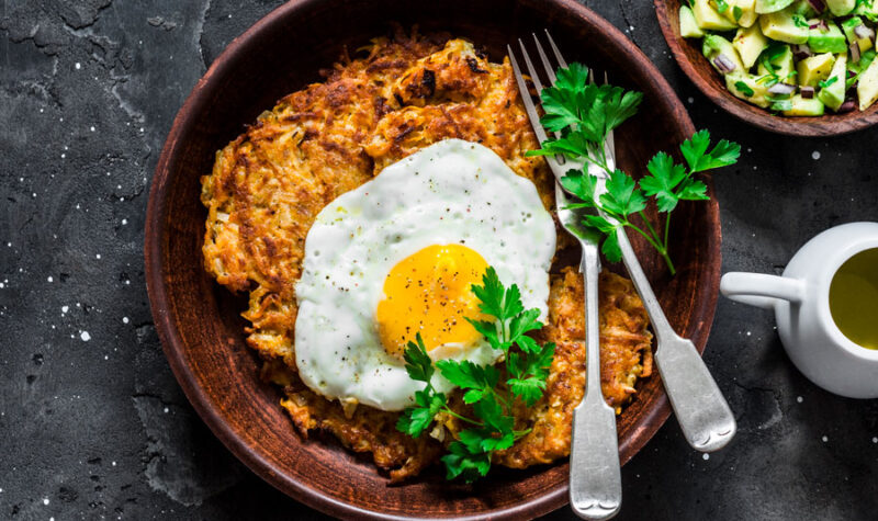 A potato pancake on a plate with an egg on top