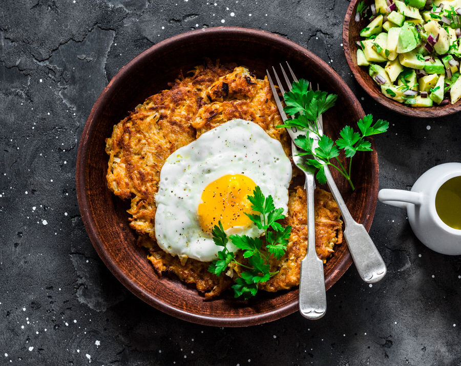 A potato pancake on a plate with an egg on top