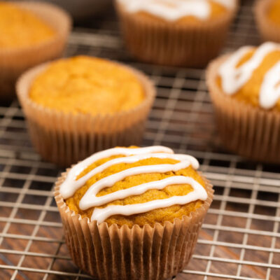 Pumpkin Applesauce muffins on a baking sheet covered in icing