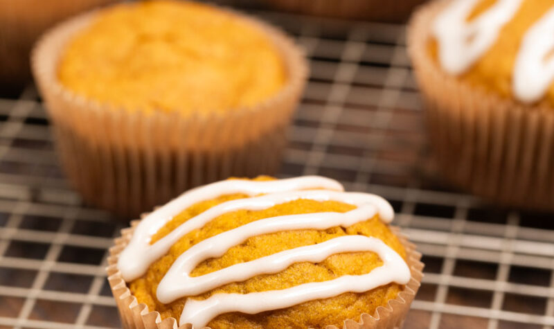 Pumpkin Applesauce muffins on a baking sheet covered in icing