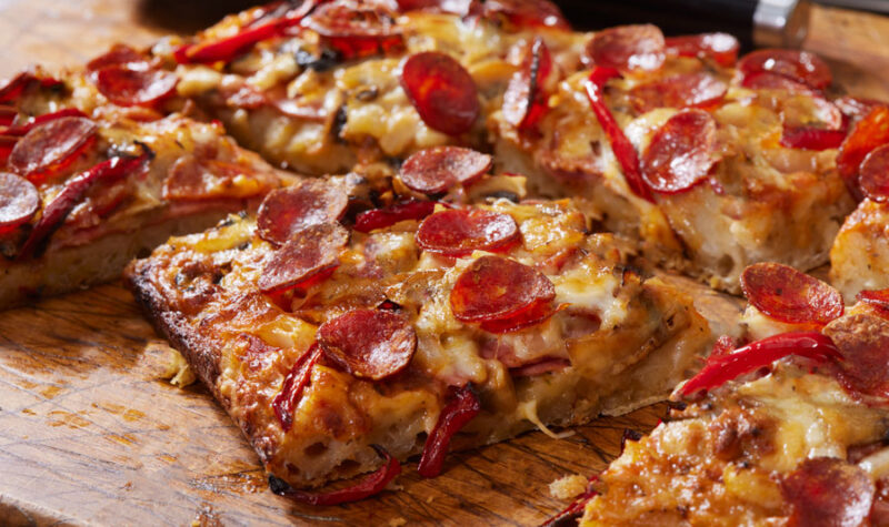 Detroit style pepperoni pizza on a cutting board