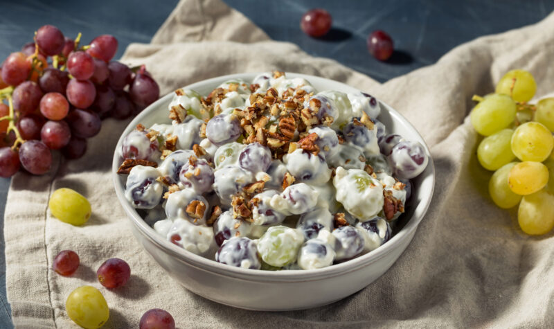 A grape salad in a bowl with grapes on the side